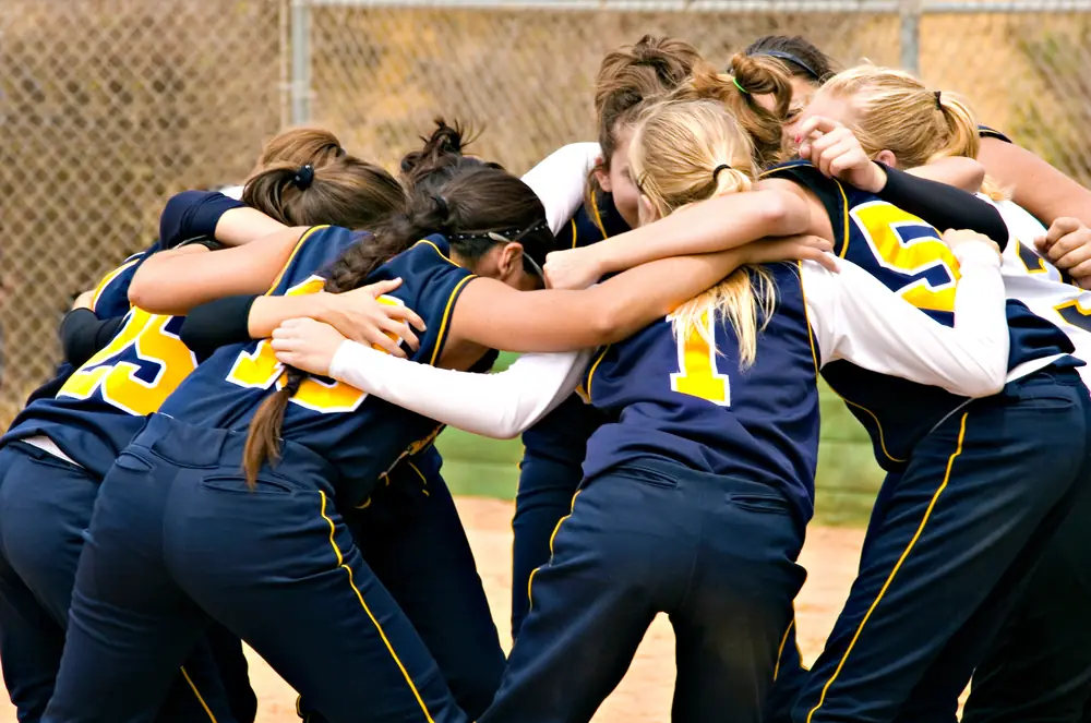Softball team huddled together before a game